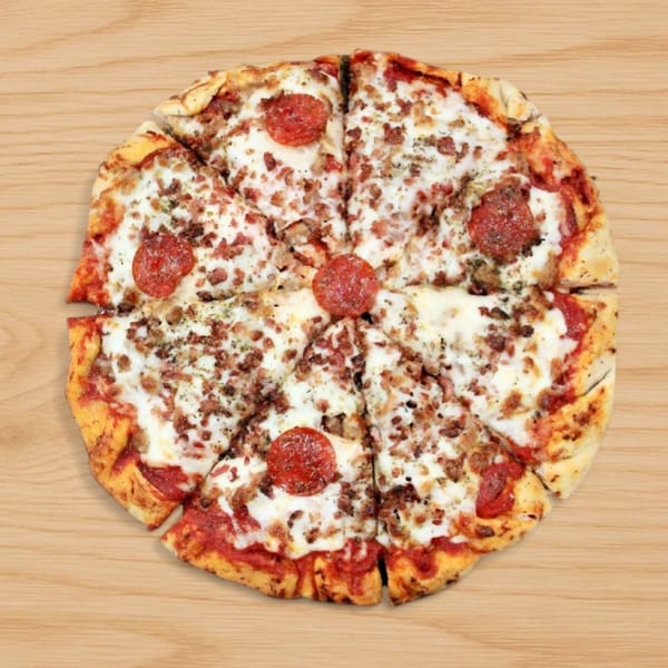 Babe's Pizza with pepperoni, sausage, and bacon, sliced into eight pieces on a wooden surface.